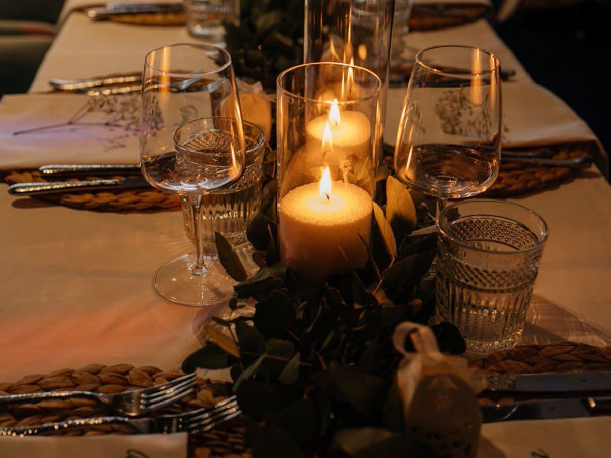 Elegante Hochzeitstafel mit warmem Kerzenlicht und gedeckten Plätzen.