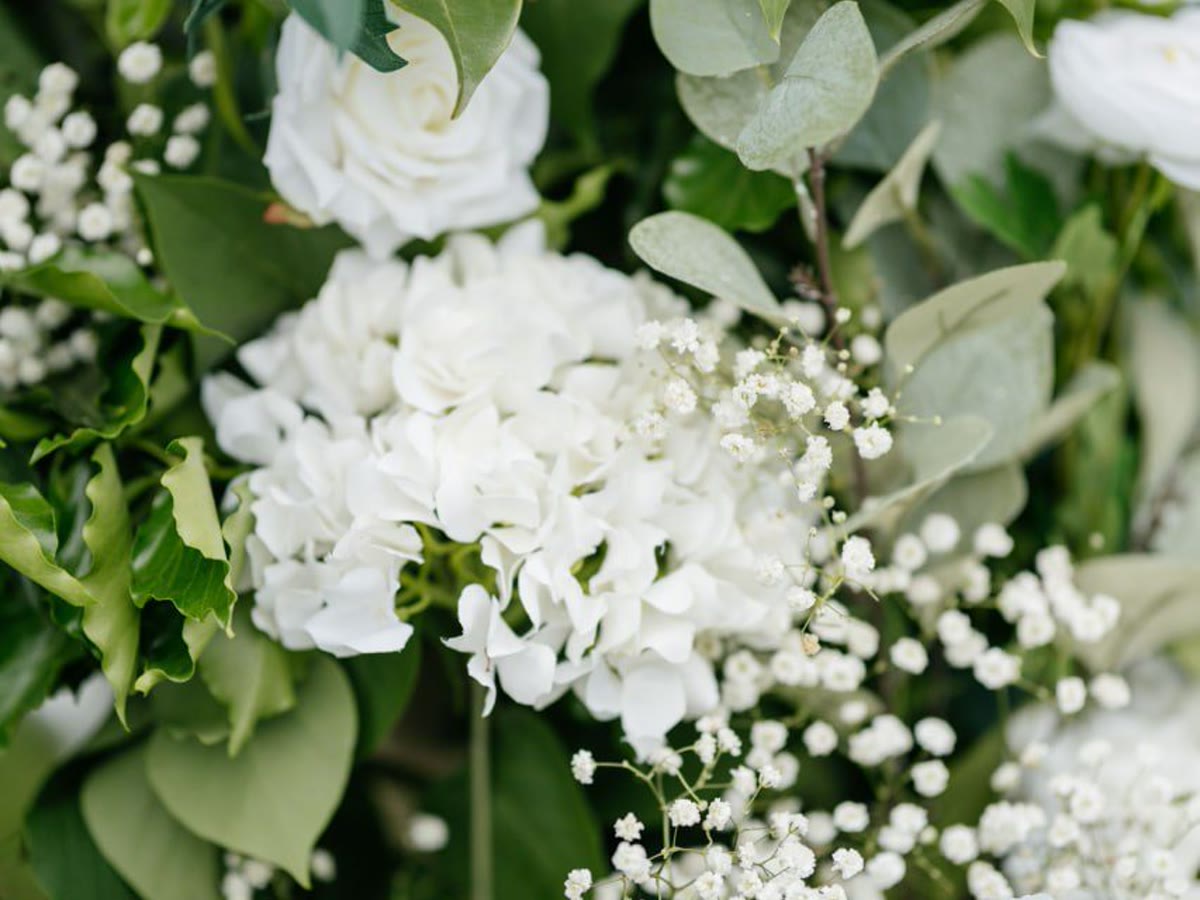 Weiße Floristikdetails mit Grün und feinen Blüten für eine Hochzeit.