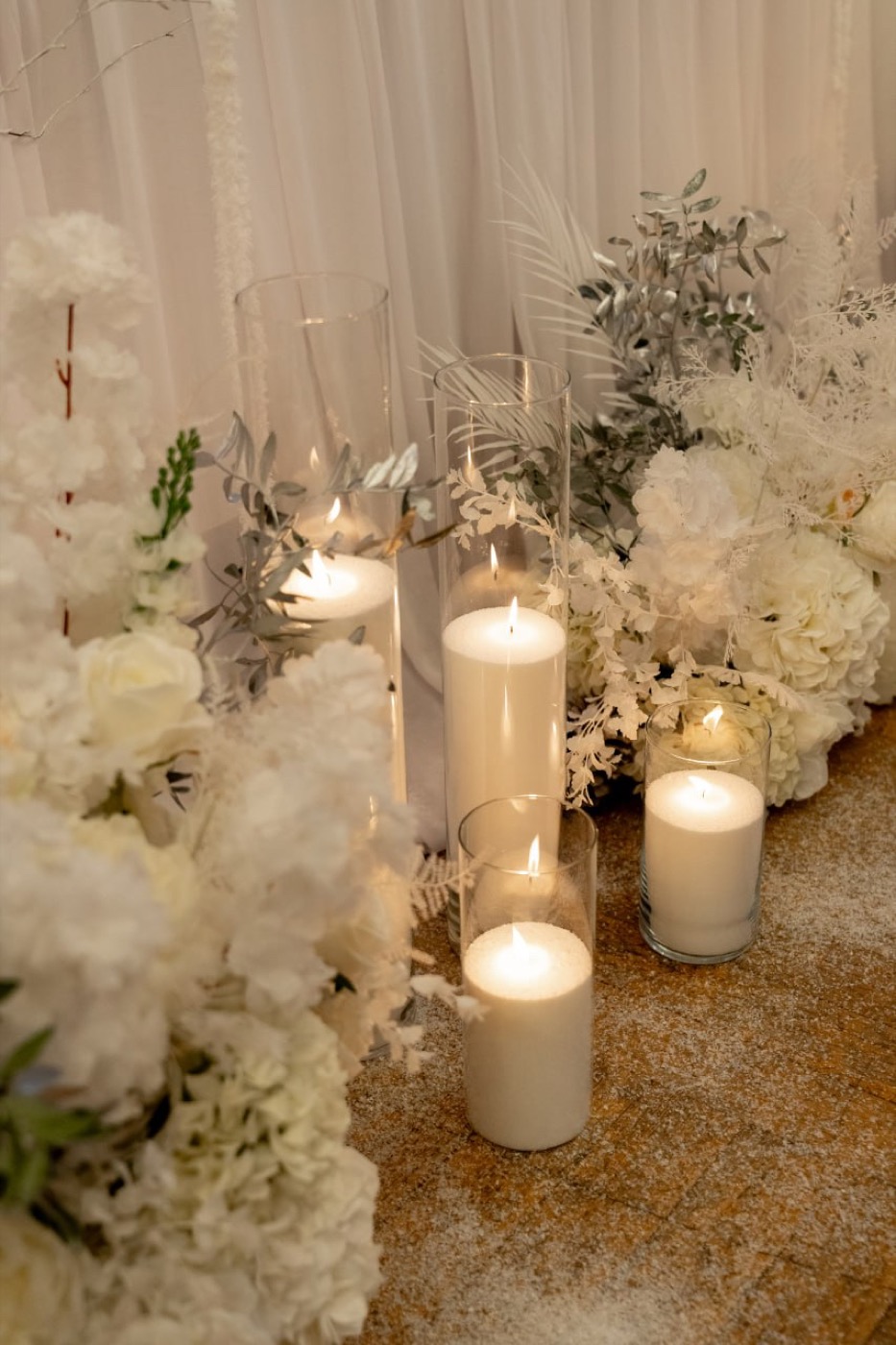 Weiße Blumen und Kerzen als ruhige Eventdekoration.