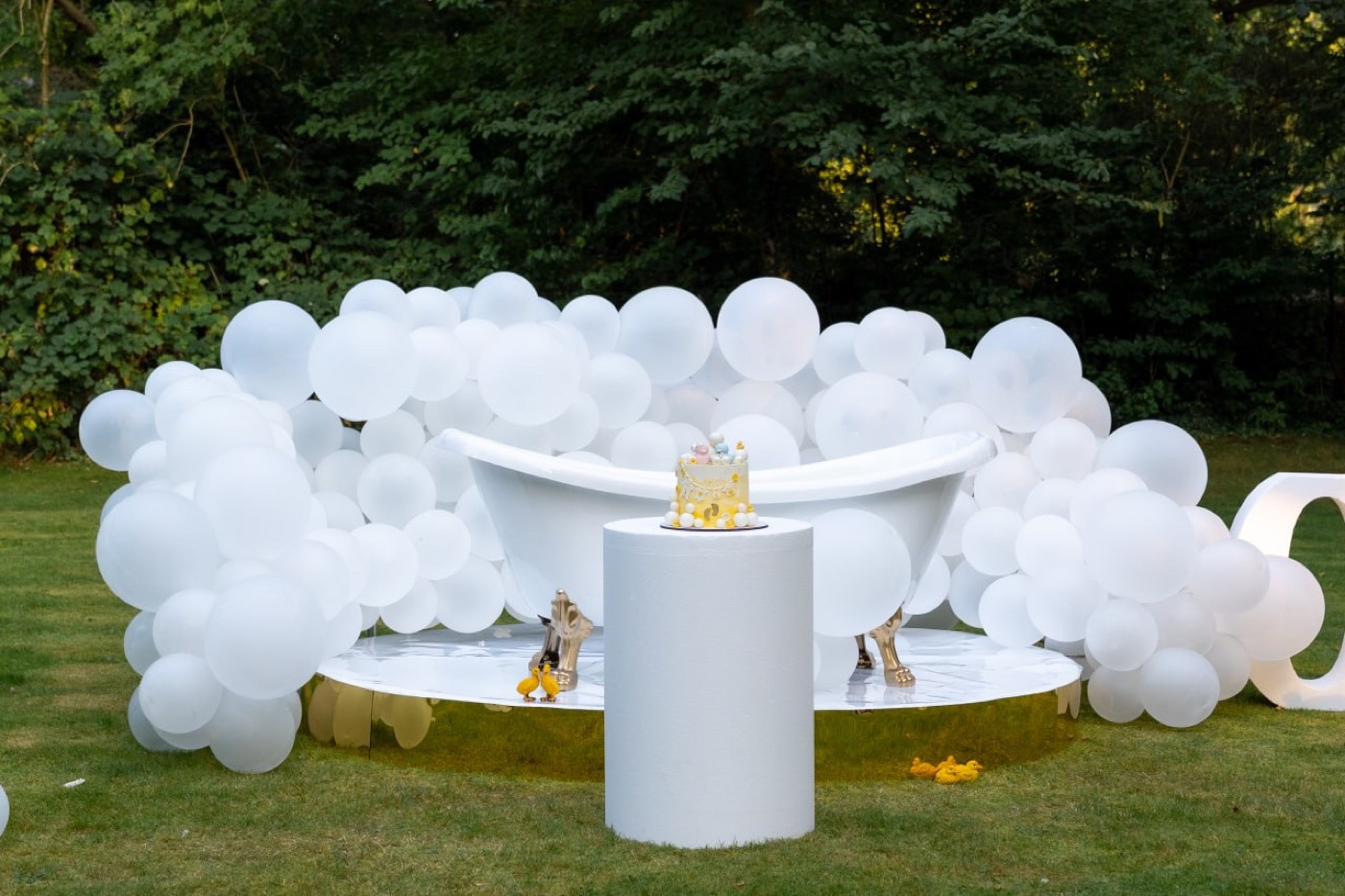 Outdoor Fotozone mit weißem Sofa, Ballons und Oh Baby Schrift.